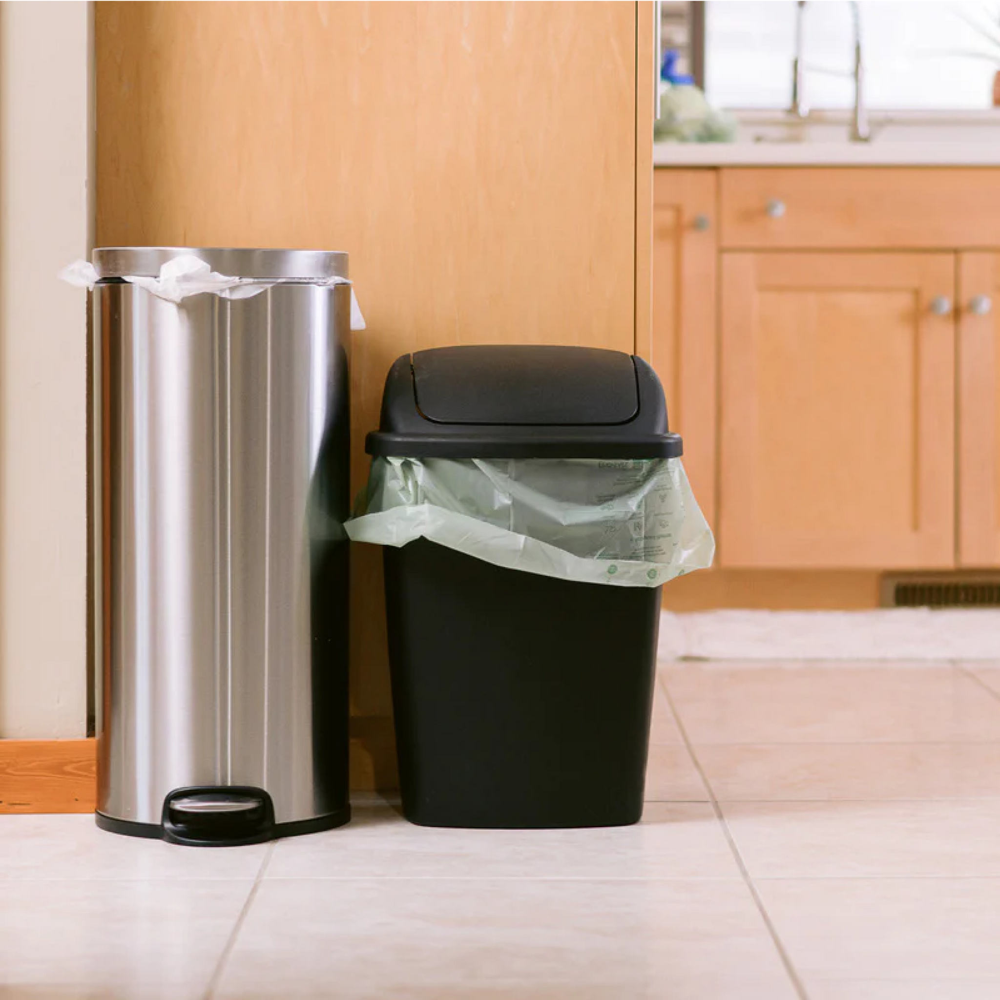 medium-sized bin with compostable bag next to a trash bin