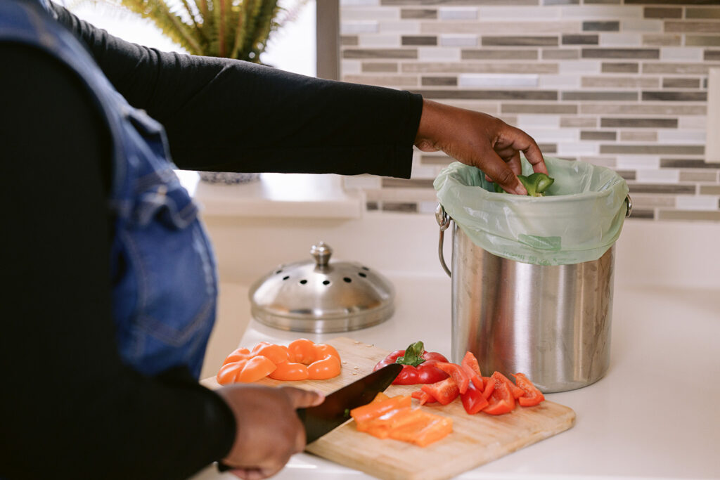 Person filling food scraps bag